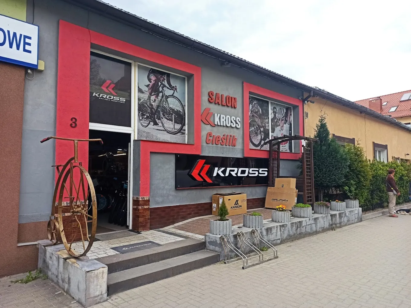 Front sklepu Sportowo-Rowerowego Cieślik w Bystrzycy Kłodzkiej — salon KROSS, witryna z rowerami, zabytkowy bicykl przy wejściu